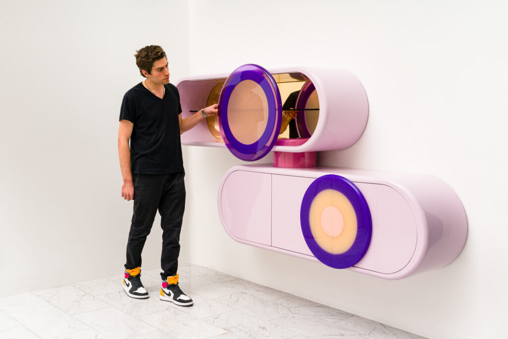 Djivan Schapira with a pair of wall mounted pink resin consoles he made