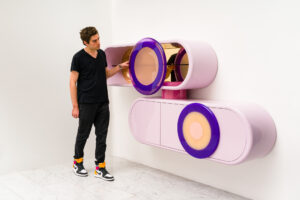 Djivan Schapira with a pair of wall mounted pink resin consoles he made